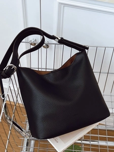Black leather hobo tote bag with silver metal buckles on a metallic trolley
