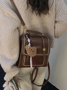 Sac bandoulière vintage marron foncé avec surpiqûres blanches et pendentif ours en peluche