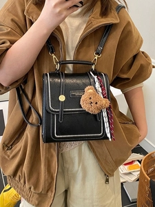 Sac à dos chic en similicuir noir avec coutures contrastées et breloque d'ours en peluche