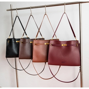 Detail view of woven leather tote bags in four classic colors with gold hardware