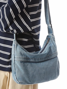 Washed blue denim crescent shoulder bag with front pocket and zipper closure