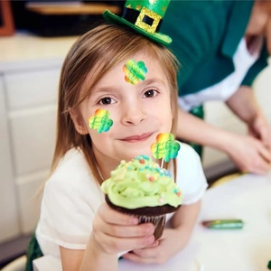 Holographic St. Patrick's Day clover sticker with Lucky text shown on a cupcake and face