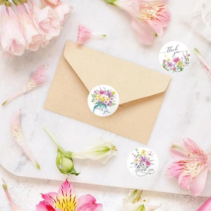 Floral Thank You stickers rolls for envelopes and gift cards on a white textured surface