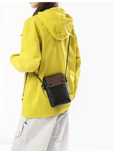 Minimalist canvas phone crossbody bag in black and brown styled with a yellow jacket