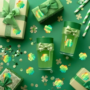 Close-up of holographic shamrock Lucky stickers on a green gift box and water bottle