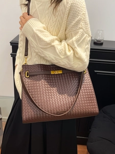 Deep brown woven leather tote bag with gold buckle hardware for daily commuting