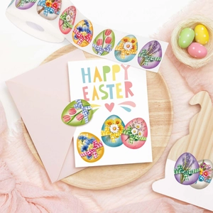 Dettaglio di adesivi colorati per uova di Pasqua con motivi floreali su vassoio in legno