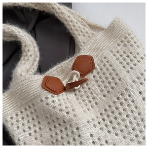 Close-up of knit tote bag featuring a vintage toggle closure and woven texture