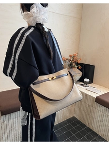 Détail du cabas en daim avec design bicolore et fermoir rotatif doré élégant