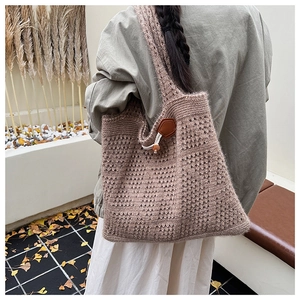 Detail of a brown knit tote bag featuring a vintage wooden buckle and mesh texture pattern