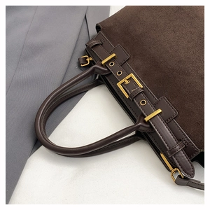 Detailed close-up of dark brown suede and smooth leather texture with gold buckle