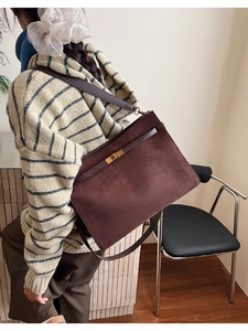 Détail du sac cabas en daim avec sangle en cuir et boucle en métal doré élégante