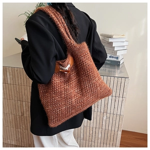Detail of caramel knit tote bag with vintage horn buckle and soft chunky texture