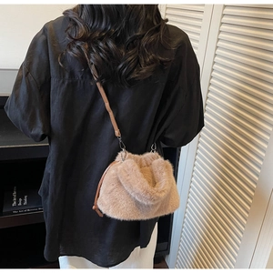 Vue détaillée du sac seau en fausse fourrure marron clair porté en bandoulière chic