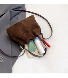 Brown suede crossbody bag showcasing spacious interior for smartphone and cosmetics