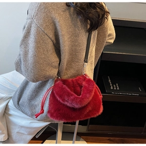 Détail du sac seau rouge en peluche avec cordon de serrage et bandoulière porté