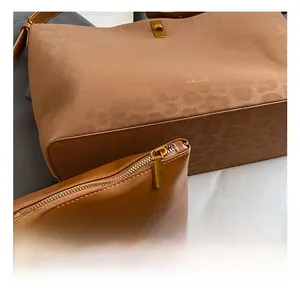 Close-up of leopard embossed tote bag with gold hardware and matching pouch set