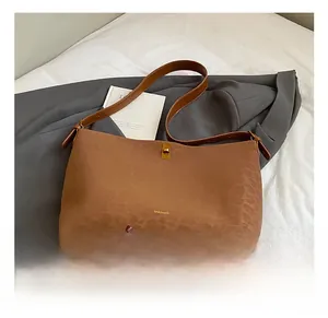 Detail of dark brown leopard embossed suede tote bag featuring a gold metal twist lock