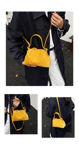 Detailed view of yellow suede cloud bag with soft pleats and matching shoulder strap