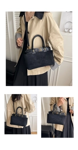 Detail view of black suede tote bag with golden metal buckle and leather trim highlights
