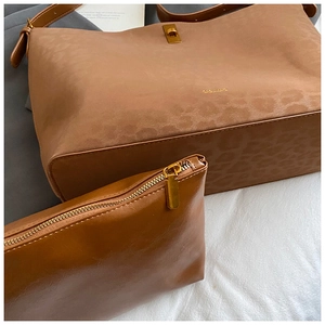 Detail of leopard print embossed suede tote bag with golden metal twist lock and inner pouch