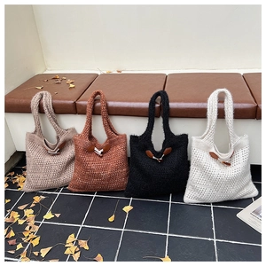Close-up of cable knit tote bags with vintage toggle buttons in four neutral colors