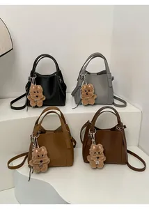 Litchi pattern leather handbags in four colors with dog charms on white display