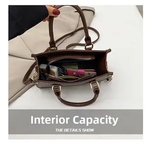 Detail view showing interior capacity and zipper pocket of the brown leather handbag