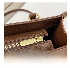 Close-up of litchi grain brown leather tote bag with premium gold metal zipper detail