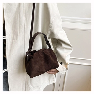 Detail showing deep brown suede cloud bag texture and silver metal side adjustment buckle