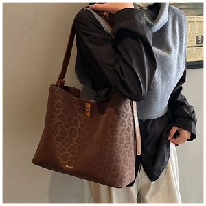 Leopard print suede tote bag with golden twist lock shown on model for size perspective