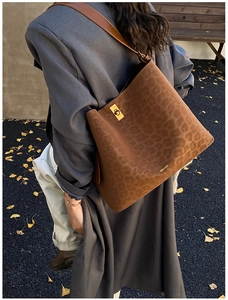 Detail of leopard print suede tote bag with leather strap and gold metallic lock detail