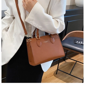 Detail of a brown lychee pattern leather handbag with adjustable crossbody strap