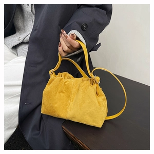 Detail of yellow suede cloud bag with drawstring pleats and adjustable strap
