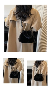 Détails d'un sac seau en fausse fourrure noire avec bandoulière en cuir sur modèle