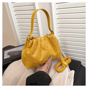 Detail of yellow ruched cloud bag with adjustable shoulder strap and soft suede texture