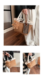 Detailaufnahme der braunen Wildledertasche mit weißem Lammfellbesatz und Teddybär-Anhänger