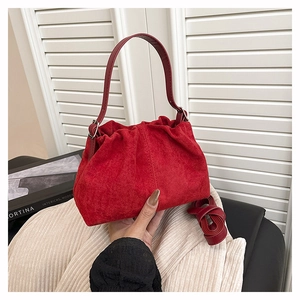 Detailed view of red suede fortune bag featuring a pleated cloud design and hand strap