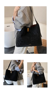 Detail of black suede tote bag with golden metal turn-lock and spacious interior design