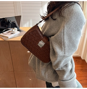 Dettaglio borsa a tracolla marrone vintage con trama intrecciata e chiusura in metallo