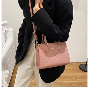 Detail of pink lychee leather handbag with golden hardware and fashion lettering