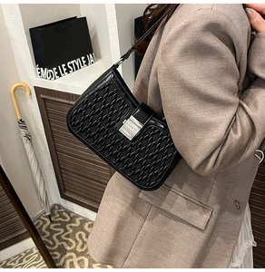 Dettaglio della borsa a spalla in pelle intrecciata nera con fibbia argentata