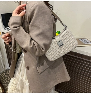 Dettaglio della borsa a tracolla bianco crema con trama intrecciata e fibbia argento