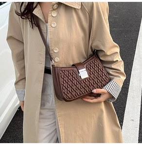 Dettaglio di una borsa a tracolla trapuntata marrone scuro con fibbia in metallo