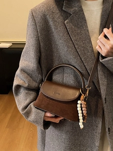 Brown leather crossbody bag with soft suede texture and elegant beaded tassel charm