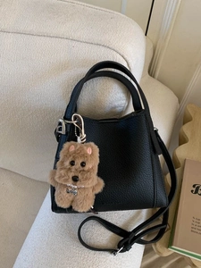 Minimalist black lychee leather bucket handbag with cute brown plush puppy pendant decor