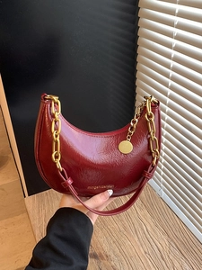 Minimalist burgundy croissant shoulder bag with gold chain and pleated glossy finish