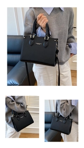 Detail of black lychee grain leather handbag with gold lettering and adjustable strap