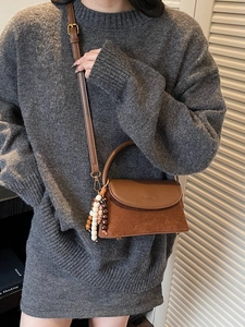 Retro brown leather crossbody bag with flap and decorative beads on a fashion model