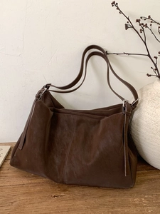Bolso tote grande retro de cuero marrón con correas dobles en mesa de madera